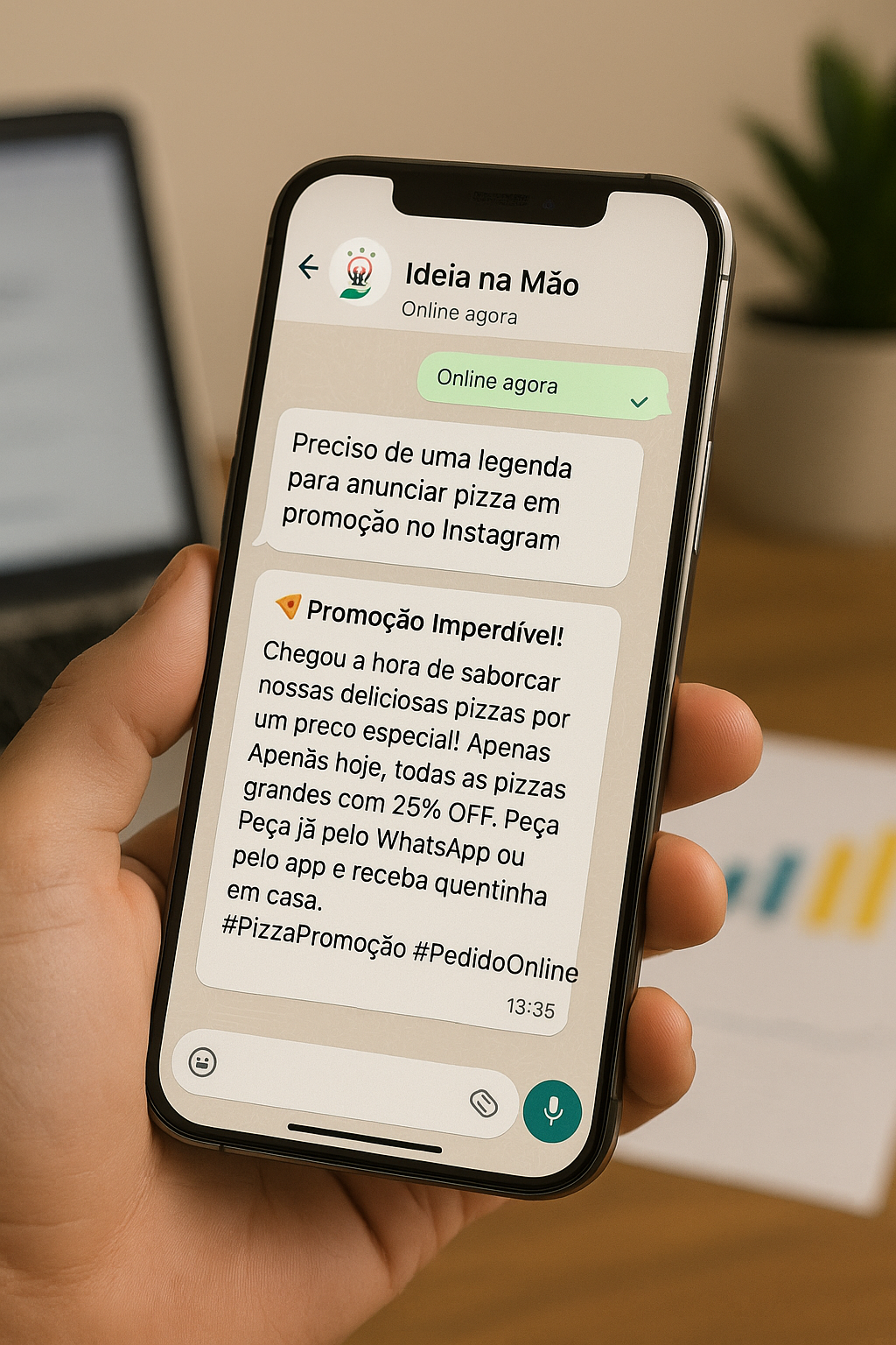 Pessoa segurando um iPhone 15 Pro exibindo uma conversa de WhatsApp com um assistente de inteligência artificial, mostrando uma legenda promocional de pizza para Instagram. Na tela, aparece a logo do Ideia na Mão e o texto da promoção, com fundo de madeira e um laptop desfocado ao fundo.